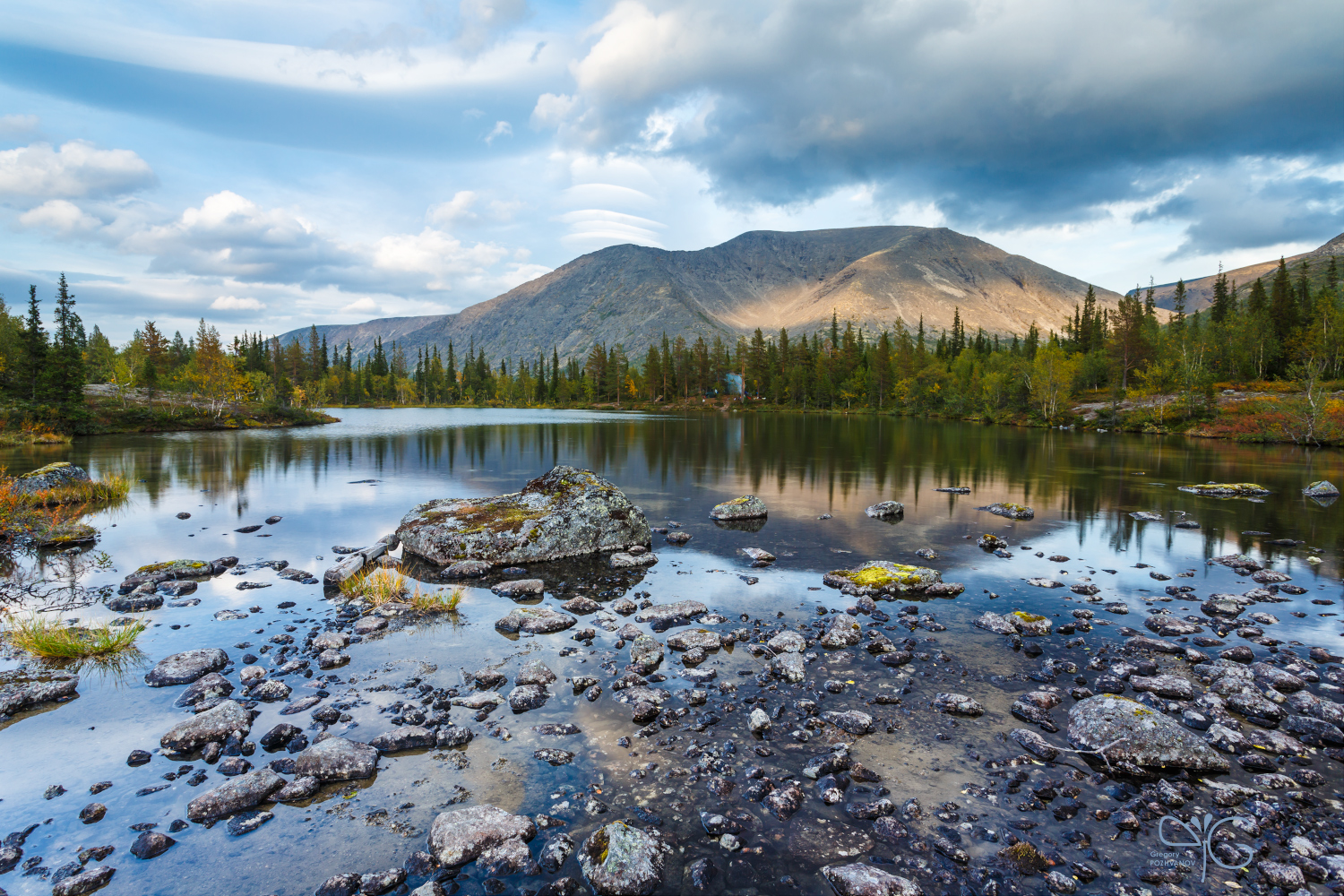 Отражение горы Рисчорр в озере с мелкими камнями